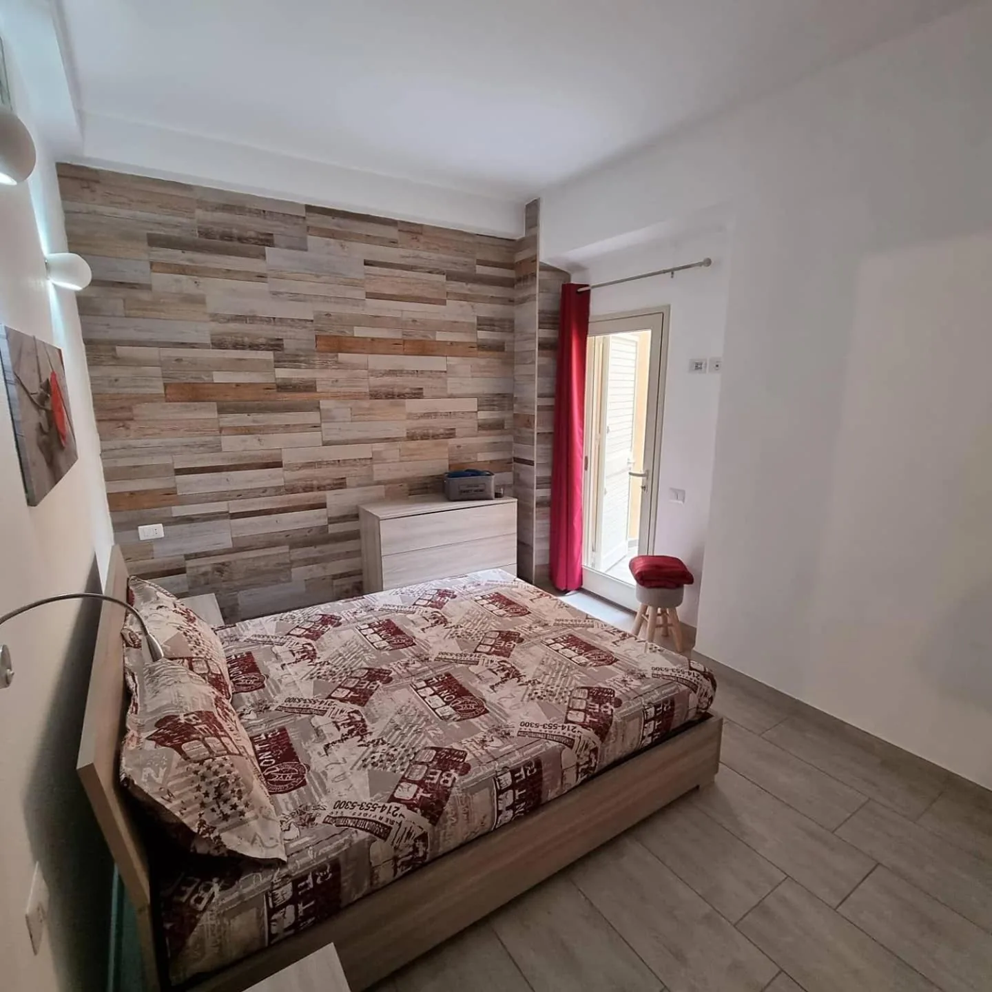 Bilocale Conti — Camera matrimoniale con parete in legno